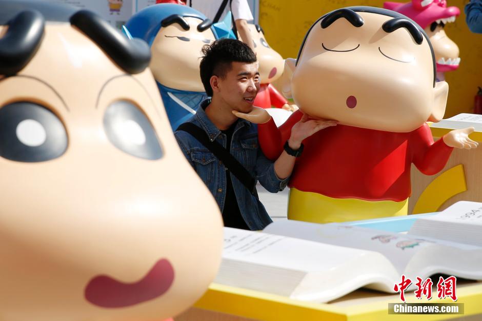 4月22日，游客與蠟筆小新合影?！跋灩P小新25周年紀(jì)念特展”日前在北京開展，吸引了不少市民游客。