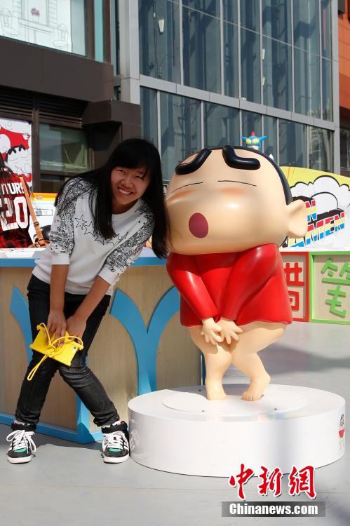 4月22日，游客與蠟筆小新合影?！跋灩P小新25周年紀(jì)念特展”日前在北京開展，吸引了不少市民游客。