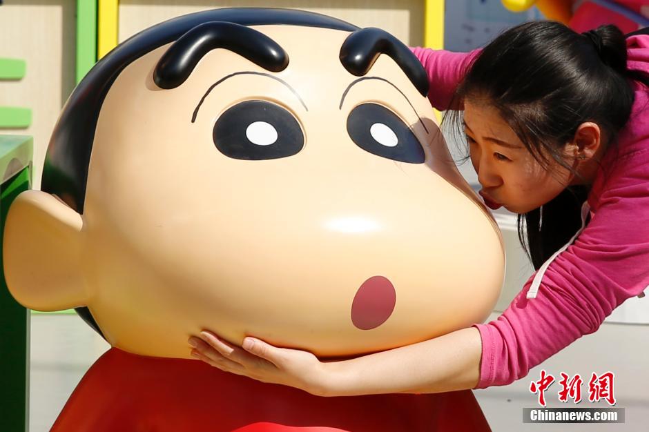 4月22日，游客與蠟筆小新合影?！跋灩P小新25周年紀(jì)念特展”日前在北京開展，吸引了不少市民游客。