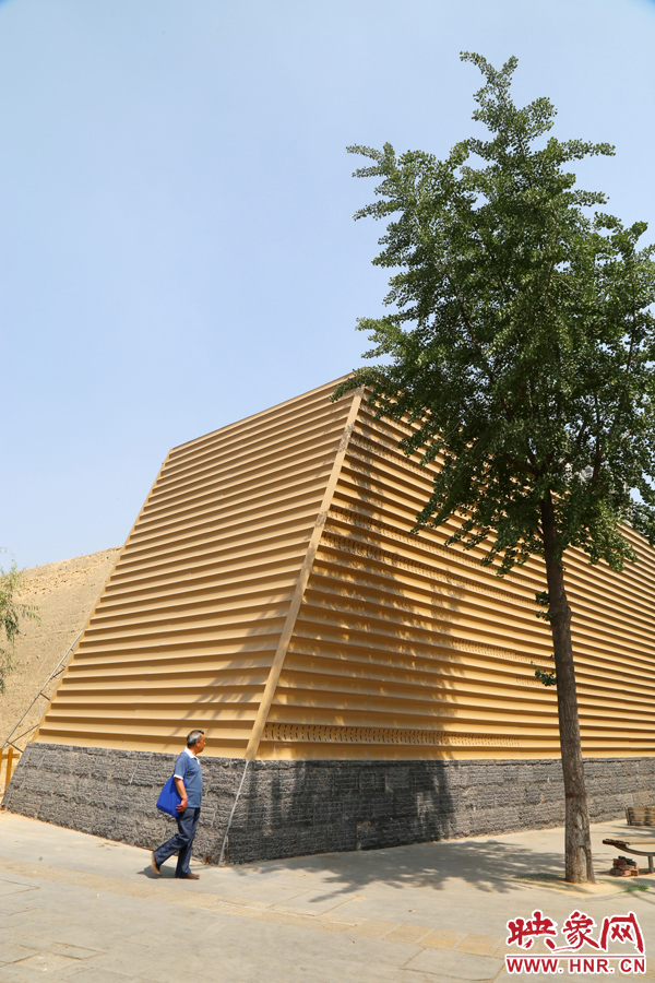 一名路人從“土豪金”保護(hù)殼前經(jīng)過。