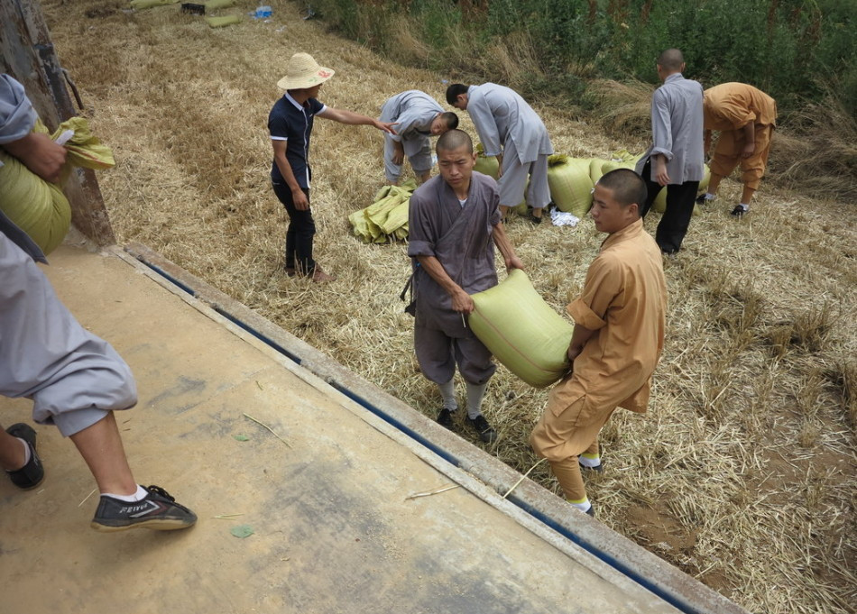 武僧將打包后的糧食集中至運(yùn)輸車(chē)輛上。