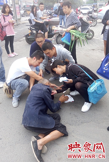 一些愛(ài)心市民在撥打了110和120后，上前給老人擦臉上的血跡。