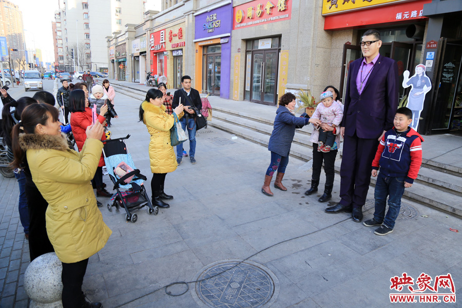 過(guò)路市民爭(zhēng)相與“巨人”合影。