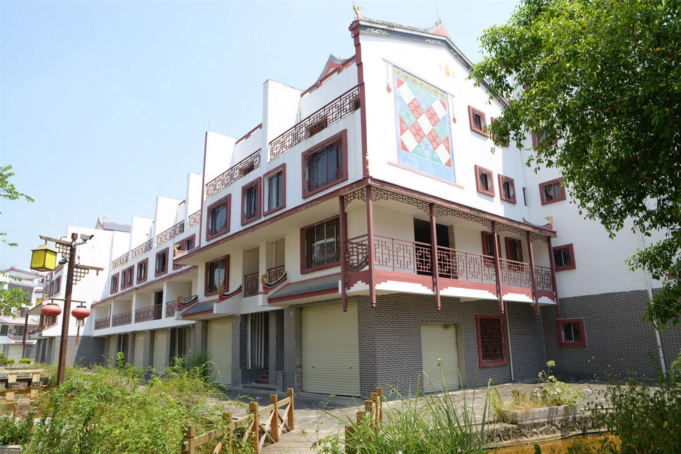 2016年7月26日，村民在廣西來賓市忻城縣隆達山水福城荒廢別墅間放牛。