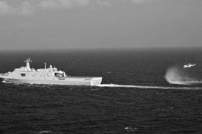 11日，抵達馬航飛機失聯(lián)海區(qū)的海軍井岡山艦與艦載直升機協(xié)同展開立體搜救行動。新華社發(fā)