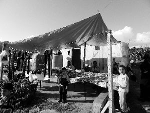 黎巴嫩一敘利亞難民營，難民支起攤鋪賣衣服掙錢。