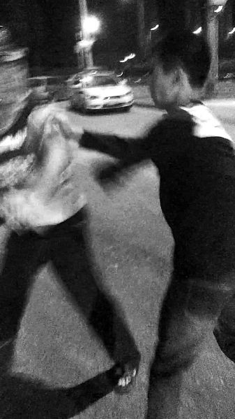 一名男子扯著民警的反光背心一路追打。