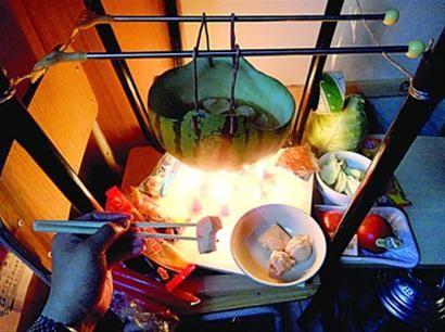 兩張椅子被面對(duì)面疊在一起，穿了兩根線的西瓜皮就懸空在椅腳中間，下面有蠟燭加熱，這就是西瓜火鍋。