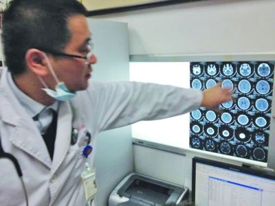 醫(yī)生在查看男孩的腦部CT片。薛馬義 攝