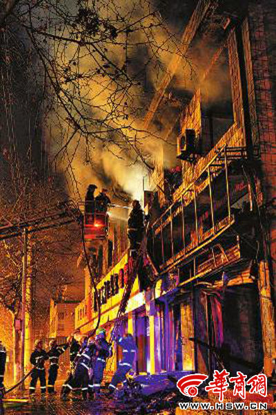 昨日22時(shí)10分，西安市豐慶路南小巷南口，消防官兵架梯子登上二樓施救 本組圖片由本報(bào)記者 閆文青 攝