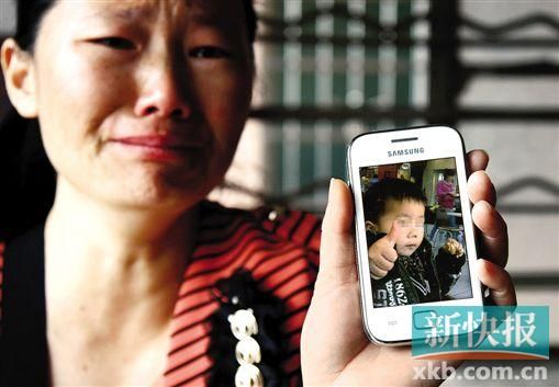 男童的舅媽拿著小益的照片,悲痛欲絕。 新快報記者 畢志毅 攝