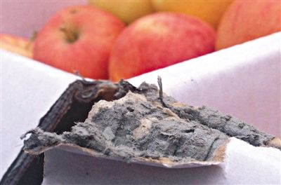 8月29日，新發(fā)地市場(chǎng)，一箱用“加重紙箱”包裝的蘋(píng)果正待售，紙箱夾層內(nèi)灰黑色的增重填充物清晰可見(jiàn)