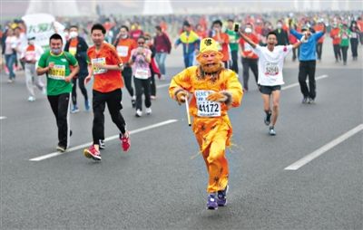 長安街，一名打扮成孫悟空的參賽者在北馬隊伍里飛奔。 本版攝影/新京報記者 吳江 李飛 王嘉寧 吳江