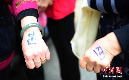 圖為10月28日，在江西九江市一家羊絨皮草服裝服飾博覽會(huì)現(xiàn)場(chǎng)，老人們正在頂著寒風(fēng)排隊(duì)等待領(lǐng)取10元代金劵。