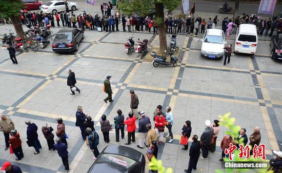 圖為10月28日，在江西九江市一家羊絨皮草服裝服飾博覽會(huì)現(xiàn)場(chǎng)，老人們正在頂著寒風(fēng)排隊(duì)等待領(lǐng)取10元代金劵。