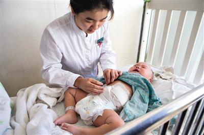 昨日，北京兒童醫(yī)院，護(hù)士為即將出院的被扎鋼針女嬰檢查傷口恢復(fù)情況。記者 高瑋 攝