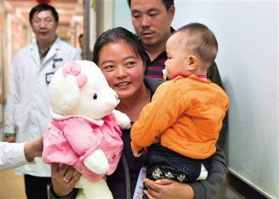 昨日上午，被扎針女嬰的母親抱著孩子和醫(yī)護(hù)人員送的玩偶準(zhǔn)備出院，院方稱孩子術(shù)后恢復(fù)良好。記者 高瑋 攝