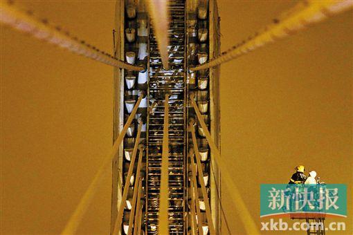 截至今日零時(shí)，男子仍未有下橋舉動(dòng)。圖為公安和消防人員乘消防云梯在高空上和男子交談。