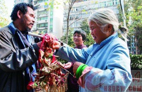 一個(gè)過(guò)路市民在挑選高廣林做的香包。