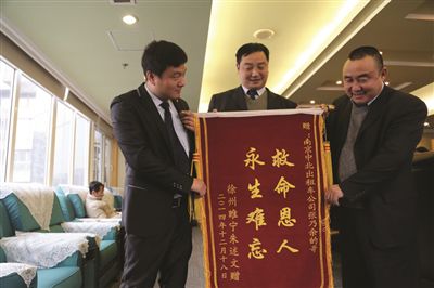 張乃余(中)和兩位救人的同伴一塊領(lǐng)獎。