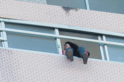 28樓的窗臺(tái)上坐著一名女子，其兩條腿耷拉在室外，不停地?cái)[動(dòng)。