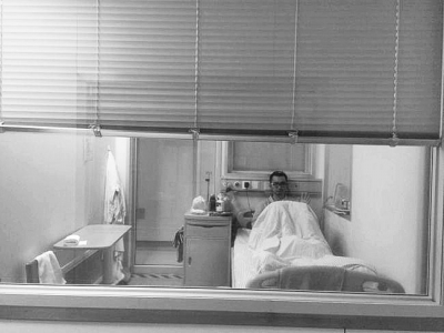 楊杰在醫(yī)院隔離病房中，沖記者揮了揮手。