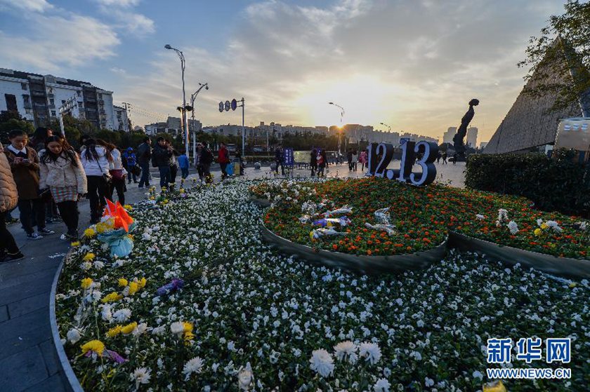 12月14日,觀眾在侵華日軍南京大屠殺遇難同胞紀(jì)念館前的“12·13”花壇上擺放鮮花祭奠遇難同胞。新華社記者 沈鵬 攝