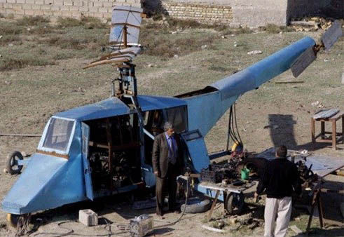 哈蒂姆·卡迪姆·薩爾曼正與工人交談，背后就是他正在制造的直升機(jī)