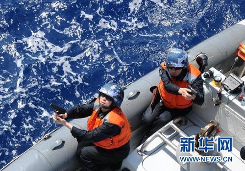 　3月28日，十余名臨檢拿捕隊員乘小艇駛至模擬可疑商船下方水面。