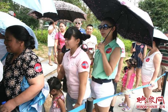 佩戴信息廣播臂貼的聽眾們?cè)谂抨?duì)等候坐帆船。