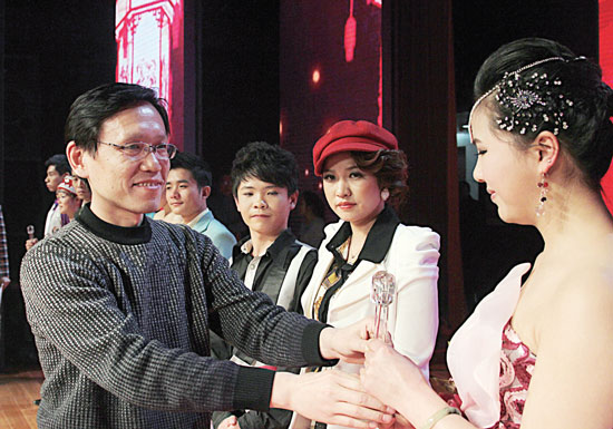 2013年2月1日，《對(duì)9當(dāng)歌》總決賽在鄭州開(kāi)唱。圖為東方今報(bào)副社長(zhǎng)胡楊為選手頒獎(jiǎng)