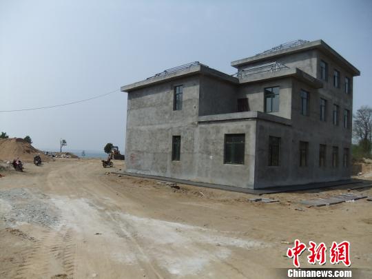 鴨河水庫庫區(qū)邊的新建別墅，一面墻上寫著“拆”，另一邊在加緊施工。吳揚(yáng)　攝