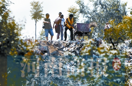 有人正在傾倒建筑垃圾，不遠(yuǎn)處就是村民的水井